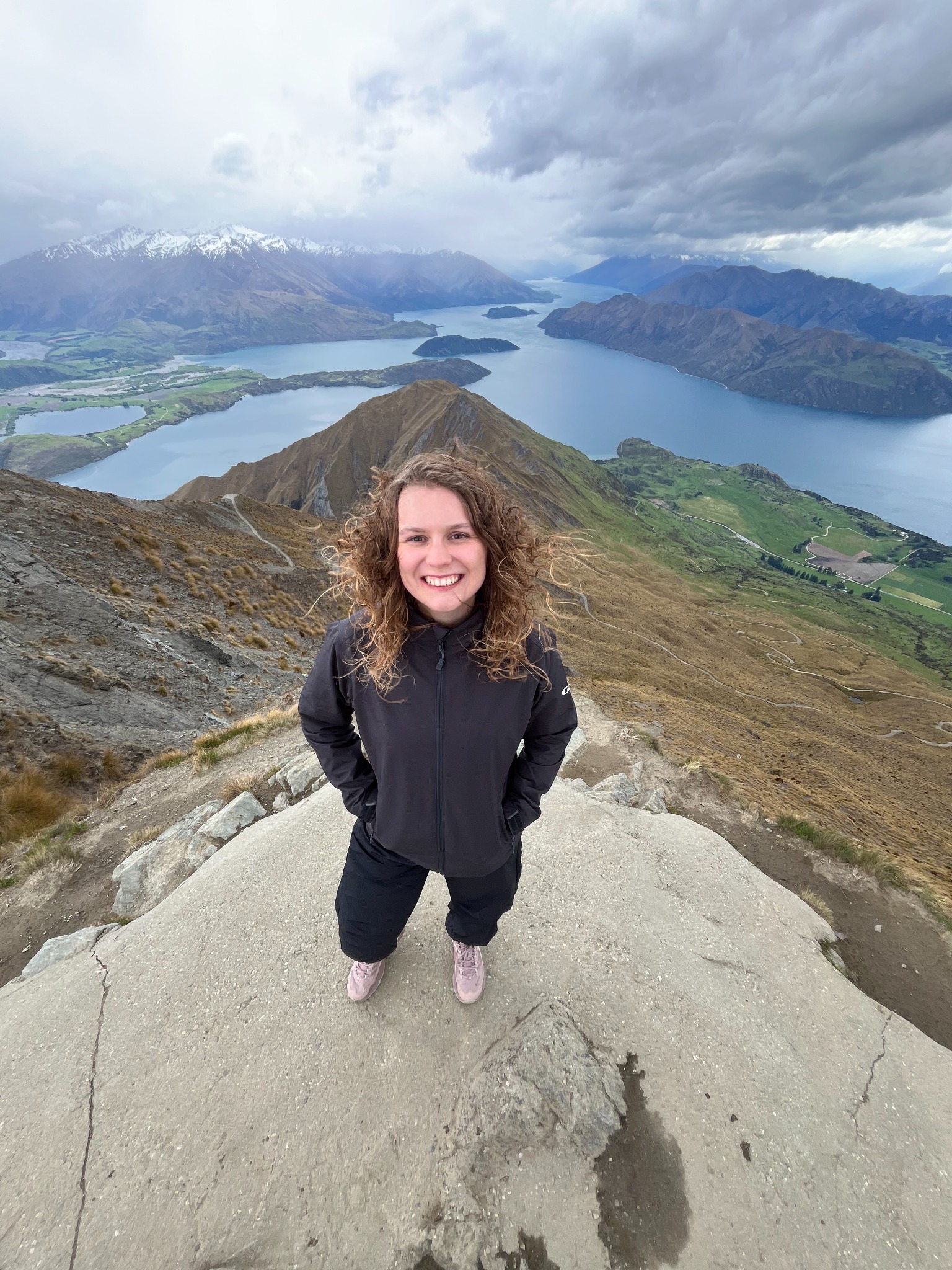 Olivia Hopkinson standing in front of a mountain and lake landscape